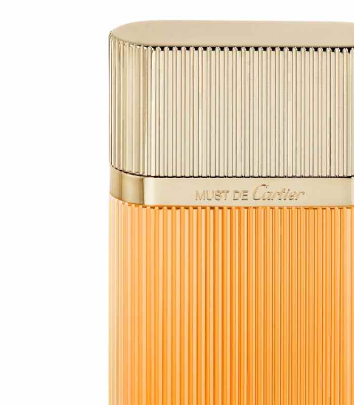 Must de Cartier perfume bottle with gold cap and orange body on a white background