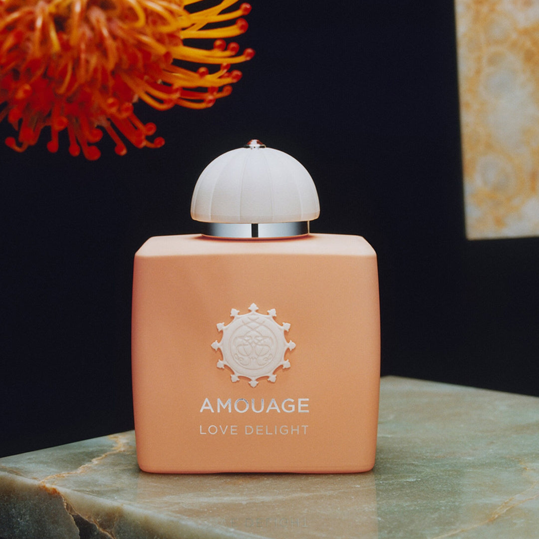 Amouage Love Delight perfume bottle on a marble surface with a dark background