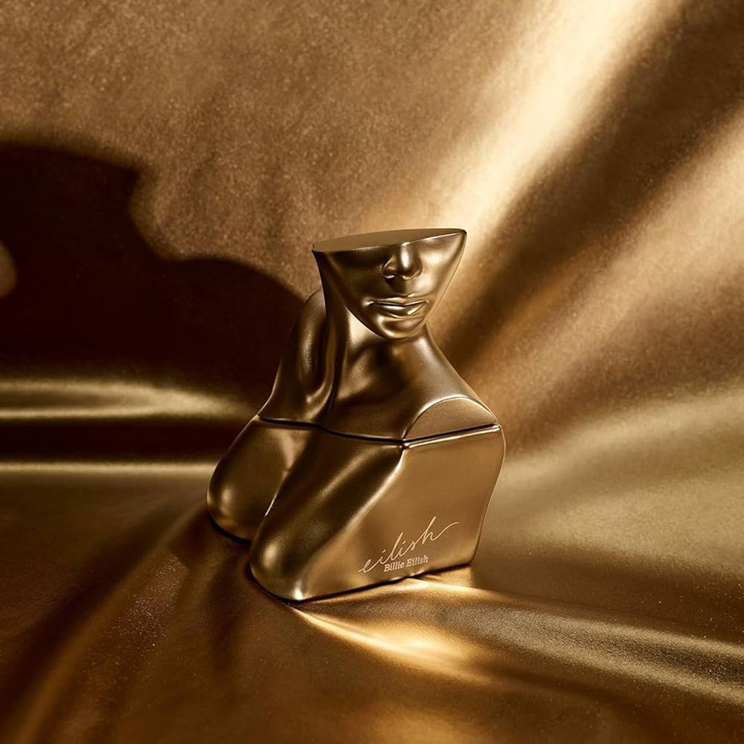 Gold perfume bottle on a reflective gold surface